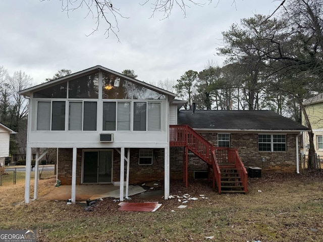 back of property with a patio area and a wall unit AC