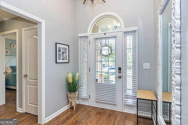 entrance foyer featuring dark wood-type flooring and an inviting chandelier