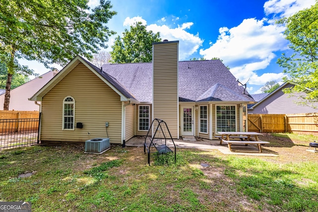 rear view of house featuring a lawn, cooling unit, and a patio