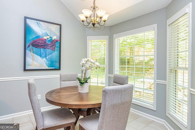 dining area featuring light tile patterned floors, vaulted ceiling, and an inviting chandelier