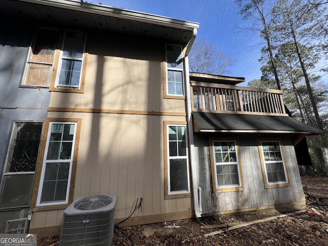 view of side of property with central AC and a balcony