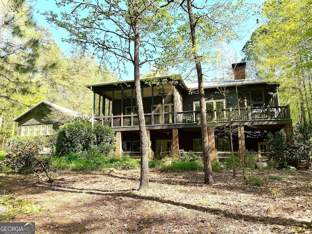 rear view of property featuring a deck and a sunroom