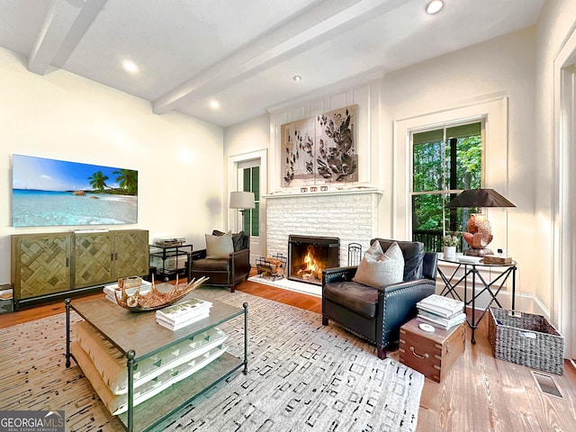 living room with light wood-type flooring, a fireplace, and beam ceiling