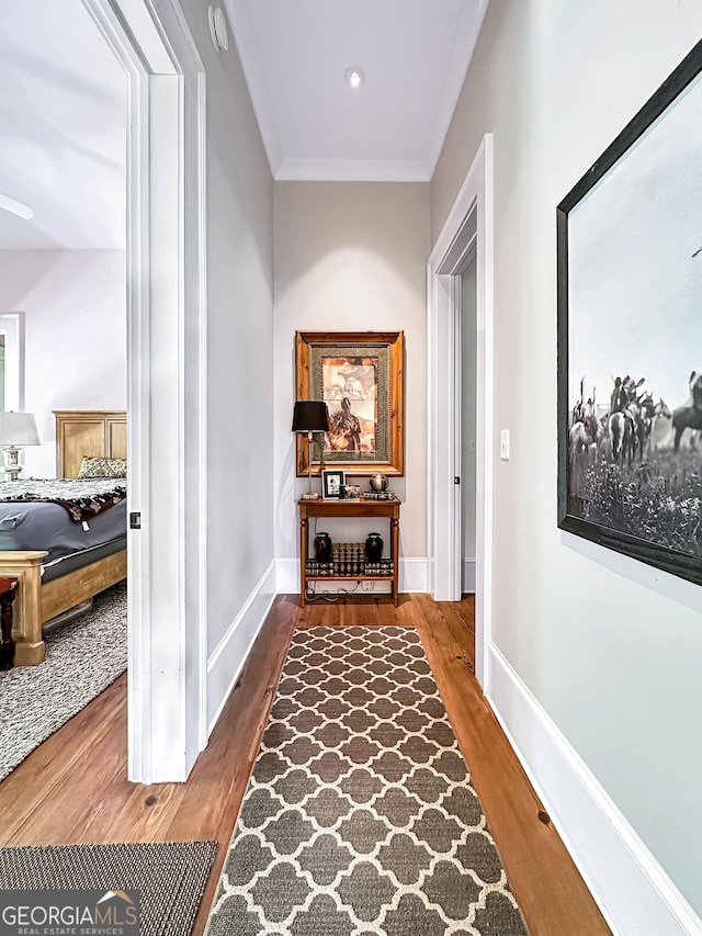 hall with ornamental molding and hardwood / wood-style flooring