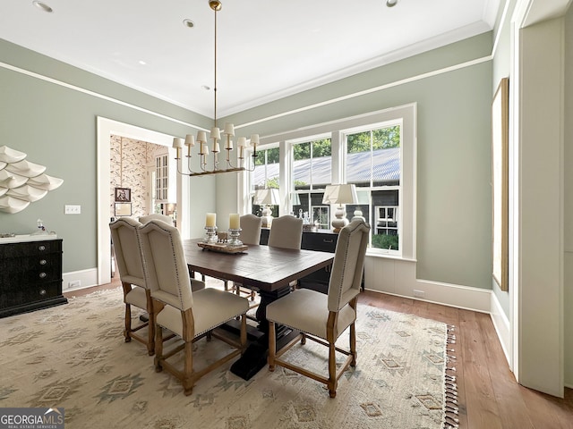 dining space featuring a chandelier, crown molding, and light hardwood / wood-style flooring