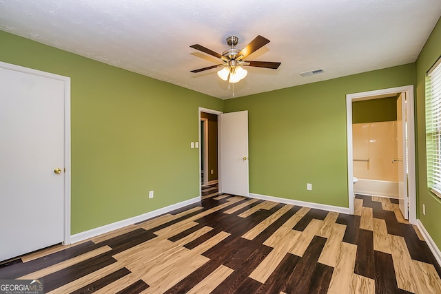 unfurnished bedroom featuring ceiling fan, connected bathroom, and hardwood / wood-style flooring