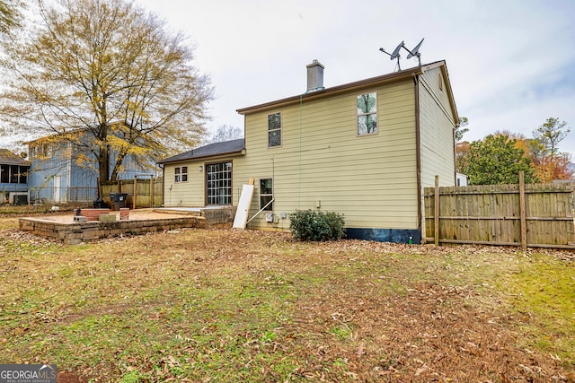 back of property with a yard and a patio