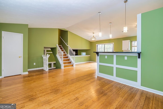 empty room with lofted ceiling and light hardwood / wood-style flooring