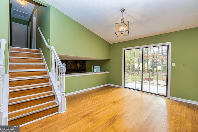 interior space featuring lofted ceiling, an inviting chandelier, and hardwood / wood-style flooring