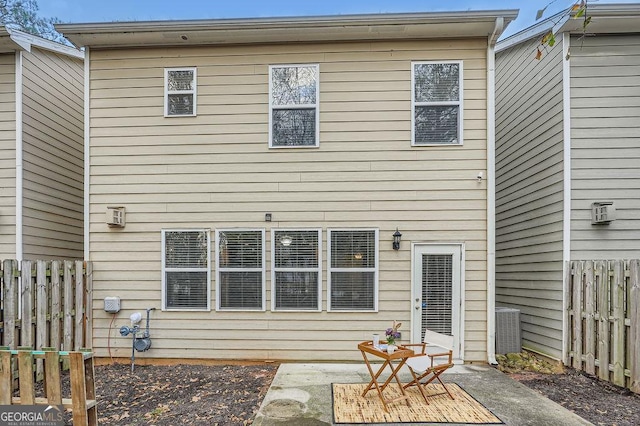 rear view of house with central AC unit and a patio area