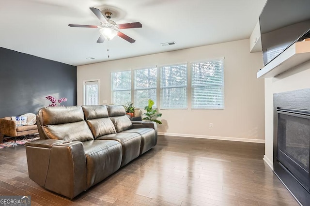 living room with dark wood-type flooring and ceiling fan