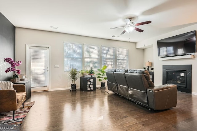 living room with ceiling fan and dark hardwood / wood-style flooring