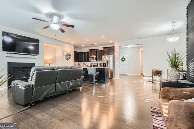 living room featuring hardwood / wood-style flooring and ceiling fan