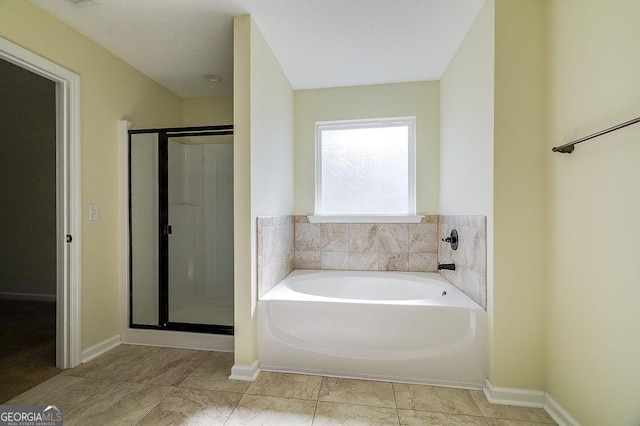 bathroom featuring a textured ceiling, tile patterned floors, and separate shower and tub