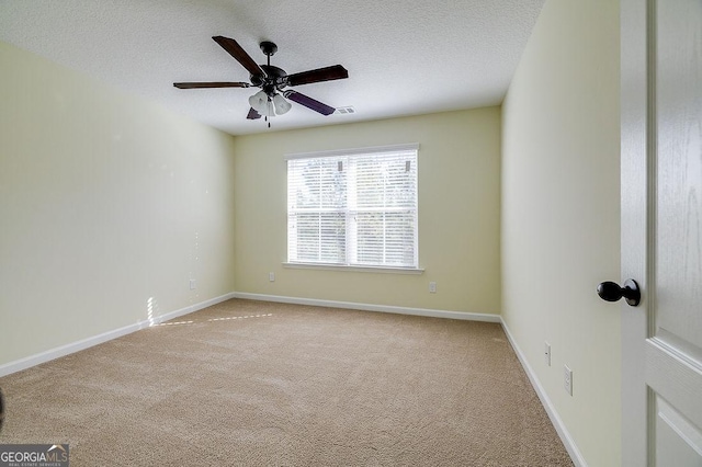 carpeted empty room with ceiling fan and a textured ceiling