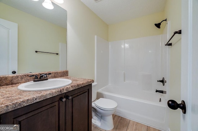 full bathroom featuring toilet, vanity, shower / bathtub combination, and a textured ceiling