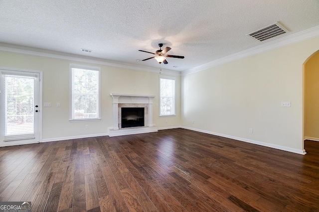 unfurnished living room featuring ceiling fan, dark hardwood / wood-style floors, crown molding, and a textured ceiling