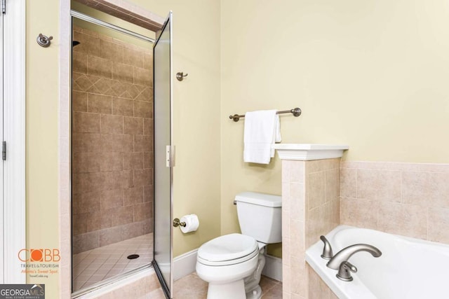 bathroom featuring toilet, a stall shower, tile patterned flooring, baseboards, and a bath