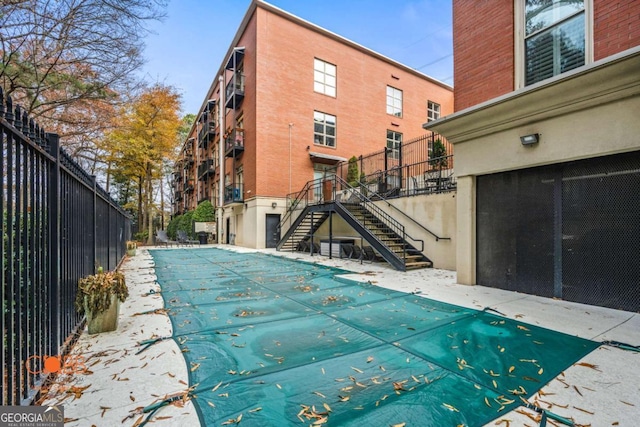 pool featuring stairs and fence