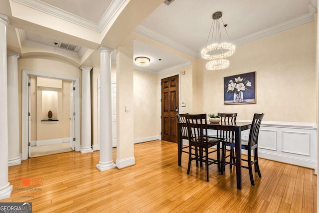 dining space featuring decorative columns, visible vents, light wood-style flooring, and crown molding