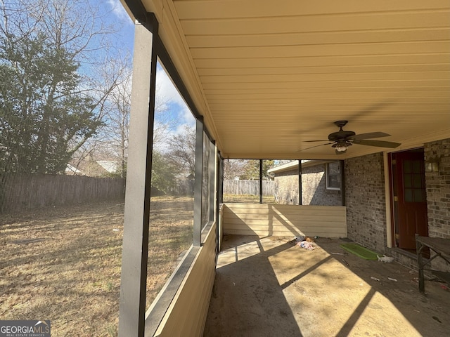 unfurnished sunroom featuring ceiling fan