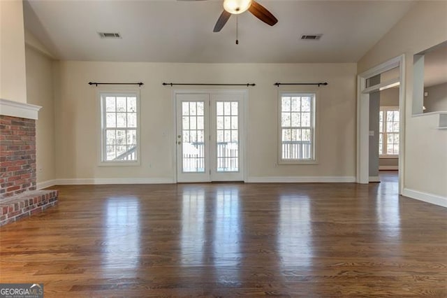 unfurnished living room with ceiling fan, vaulted ceiling, dark hardwood / wood-style flooring, and a fireplace