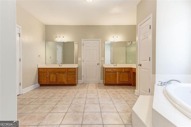 bathroom featuring vanity, tile patterned floors, and a relaxing tiled tub