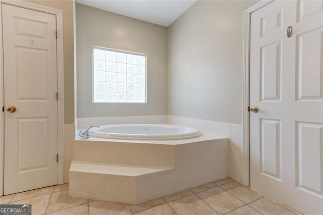 bathroom featuring a relaxing tiled tub and tile patterned floors