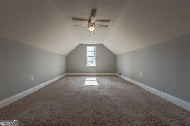 bonus room featuring a textured ceiling, carpet floors, ceiling fan, and vaulted ceiling