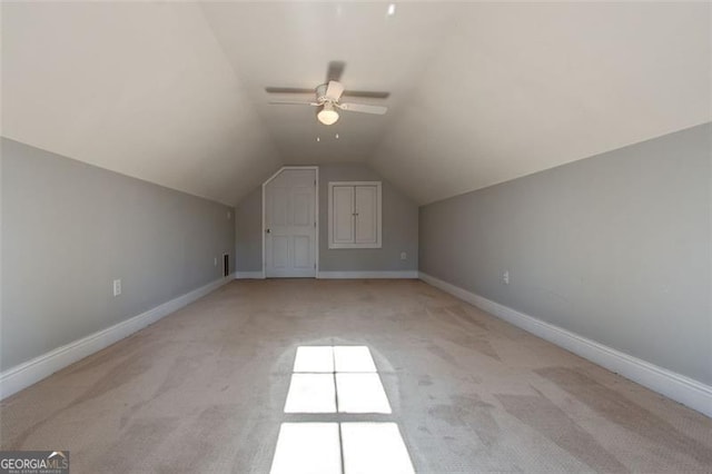 bonus room with ceiling fan, light colored carpet, and vaulted ceiling