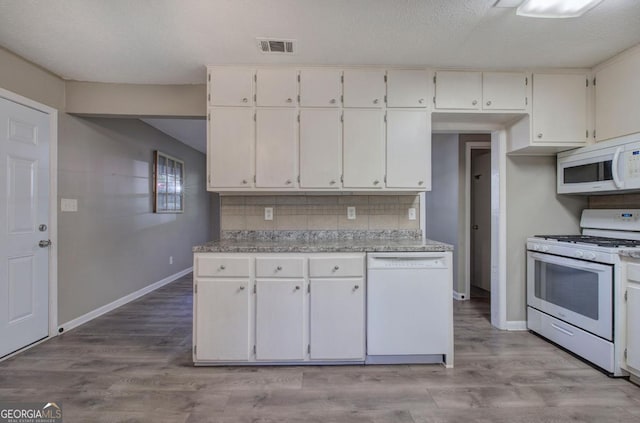 kitchen with tasteful backsplash, white appliances, and white cabinetry