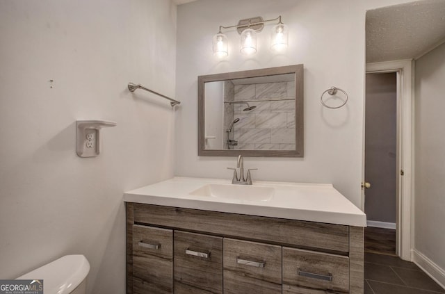 bathroom featuring toilet, tile patterned flooring, and vanity