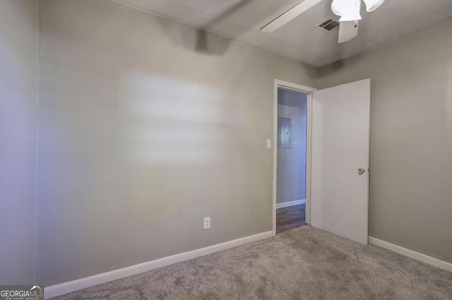 empty room with carpet floors, ceiling fan, a textured ceiling, and electric panel