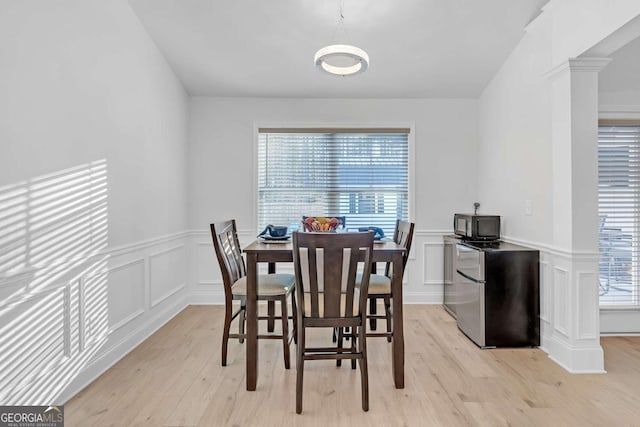 dining space featuring ornate columns and light hardwood / wood-style flooring