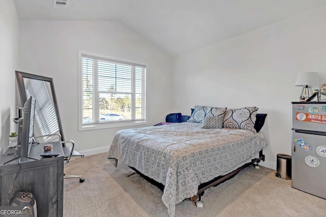 carpeted bedroom with lofted ceiling and stainless steel fridge