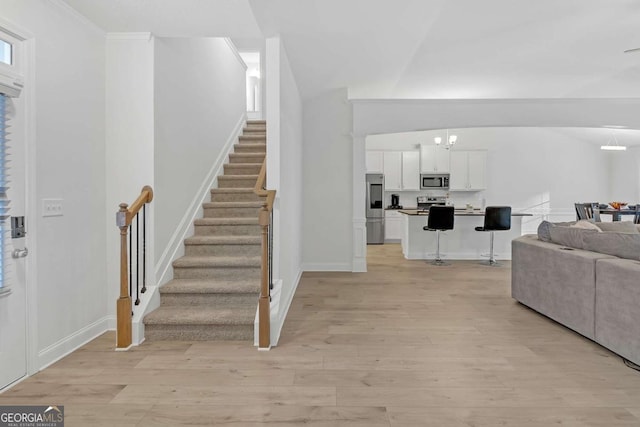 foyer entrance featuring light wood-type flooring and crown molding