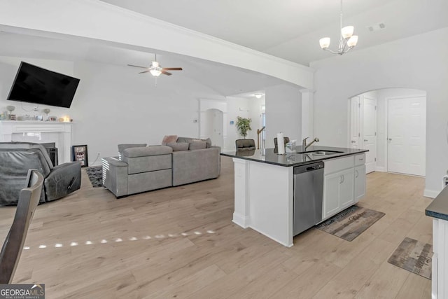 kitchen featuring white cabinetry, decorative light fixtures, a kitchen island with sink, stainless steel dishwasher, and sink