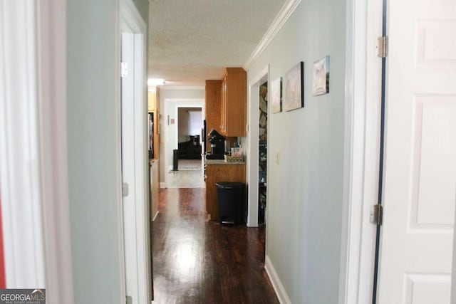 hall featuring a textured ceiling, dark hardwood / wood-style flooring, and crown molding