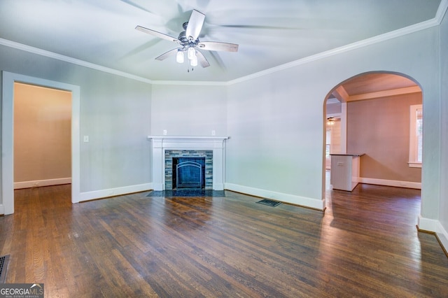 unfurnished living room featuring ceiling fan, dark hardwood / wood-style floors, a stone fireplace, and ornamental molding