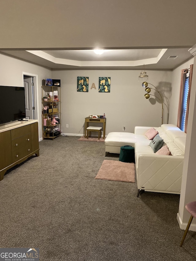 carpeted living room featuring a tray ceiling