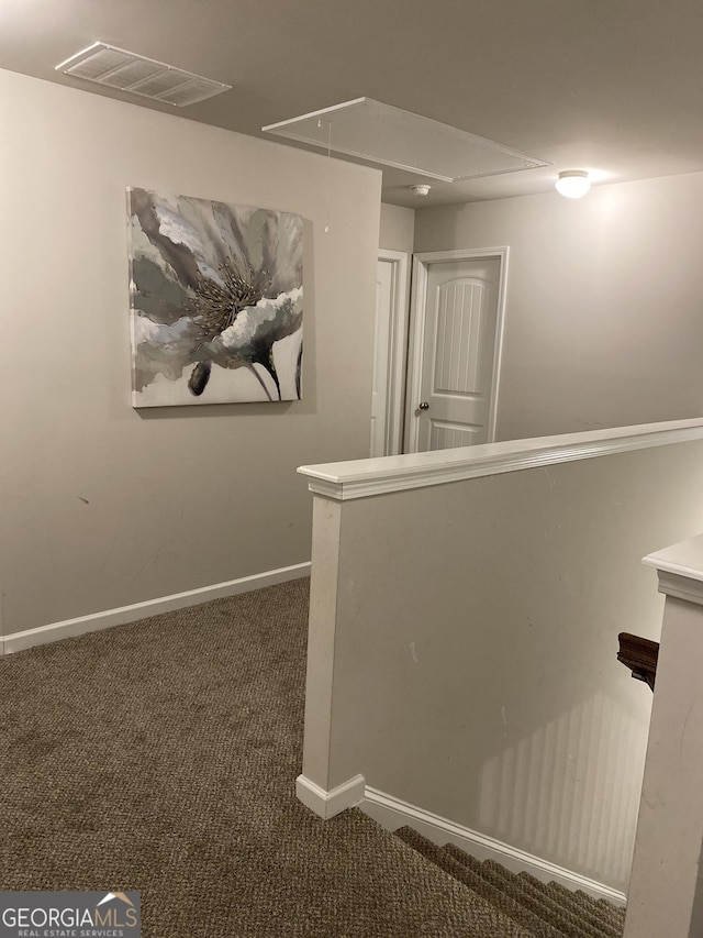 hallway with dark colored carpet