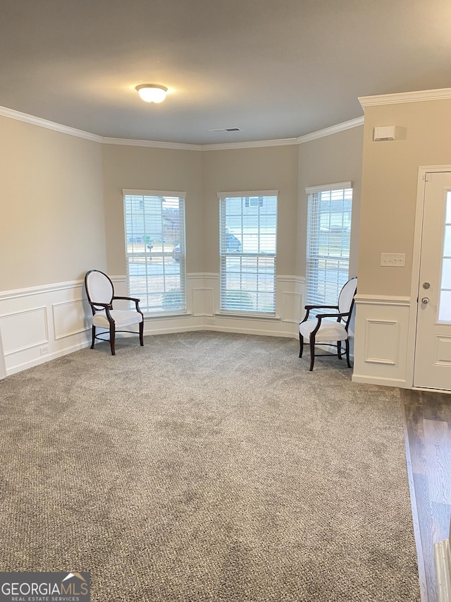 living area featuring crown molding and carpet flooring