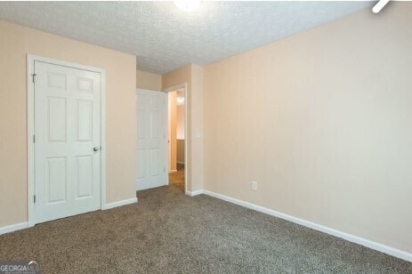 unfurnished bedroom with carpet flooring and a textured ceiling