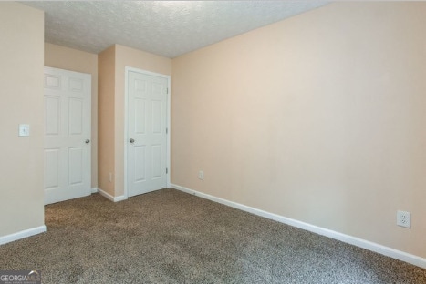 unfurnished bedroom featuring a textured ceiling and carpet