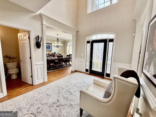 foyer featuring crown molding, an inviting chandelier, and light hardwood / wood-style flooring