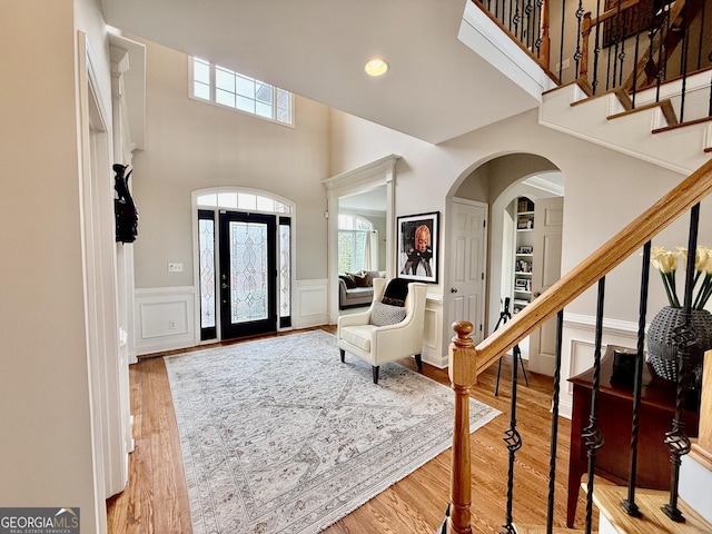 entryway featuring hardwood / wood-style floors and a towering ceiling