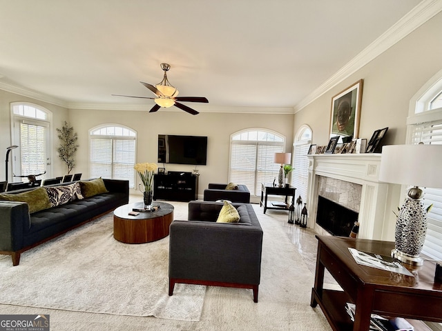 living room featuring a premium fireplace, ornamental molding, and ceiling fan