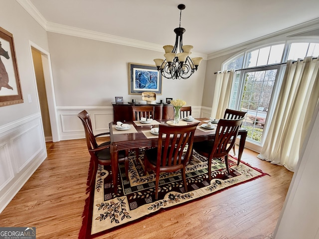 dining room featuring a notable chandelier, ornamental molding, and light hardwood / wood-style floors