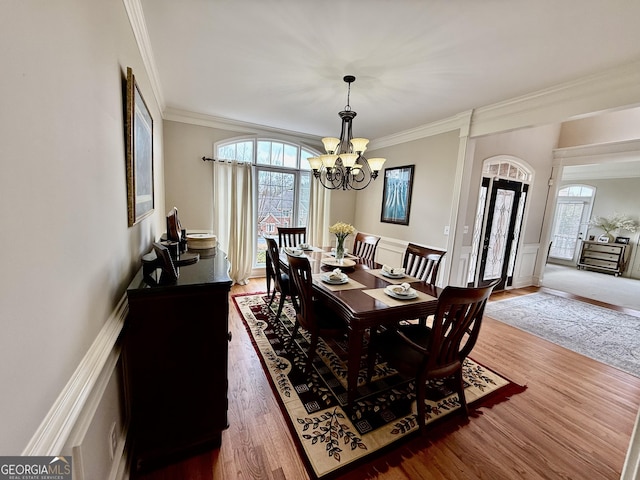 dining space with dark hardwood / wood-style flooring, a healthy amount of sunlight, a chandelier, and ornamental molding