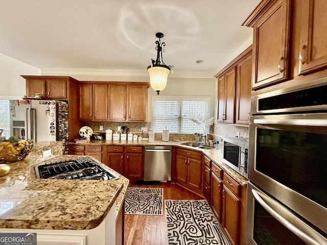 kitchen with appliances with stainless steel finishes, decorative backsplash, sink, hanging light fixtures, and dark hardwood / wood-style floors